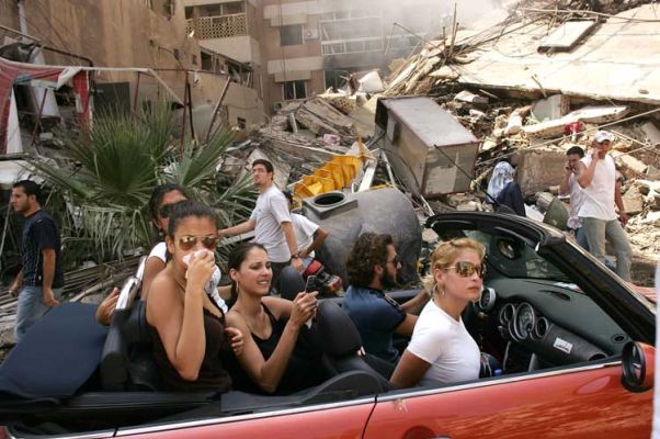 Jonge Libanezen rijden door verwoeste buurt van Zuid-Beiroet, 15 augustus 2006. World Press Photo 2006, Spencer Platt.